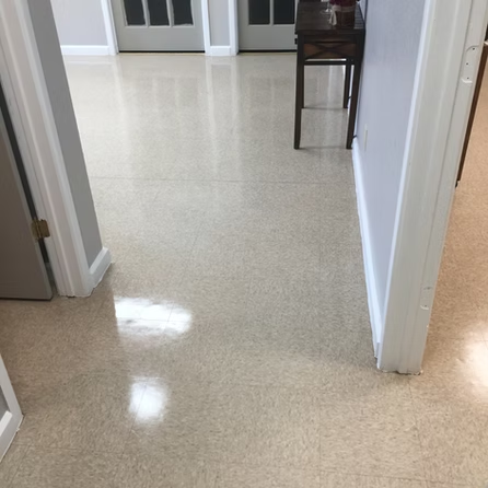 A hallway with a table in the middle of it and a shiny floor.