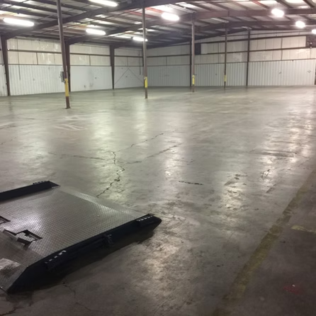 An empty warehouse with a forklift on the floor