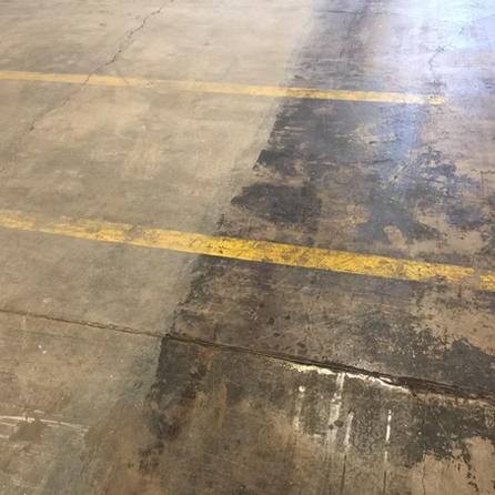 A dirty concrete floor with a yellow line on it.