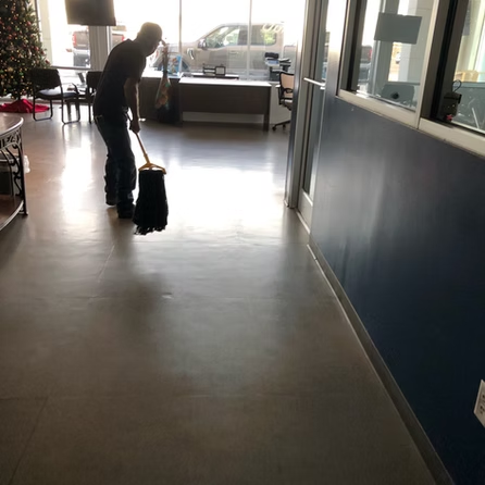 A man is mopping the floor in a hallway
