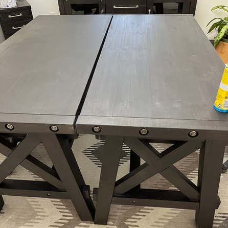 A wooden table with a bottle of soap on it