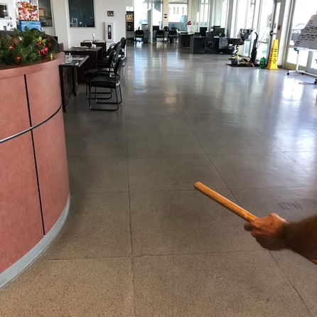 A person holding a wooden stick in a lobby