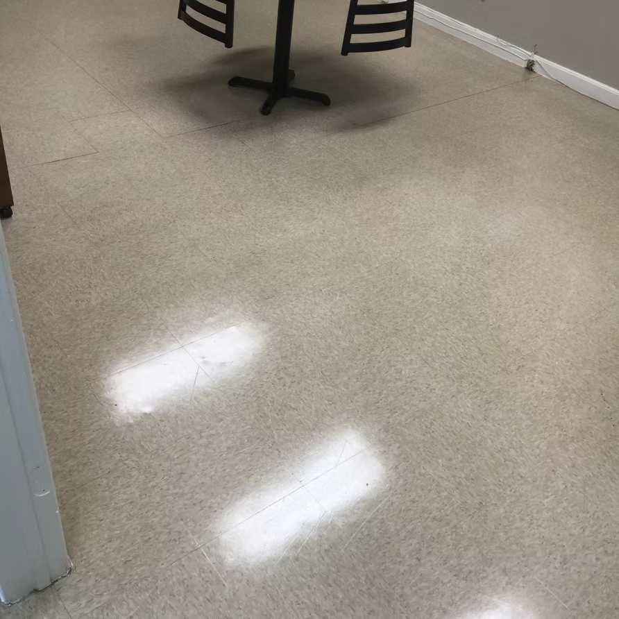 A table and chairs are sitting on a tiled floor in a room.