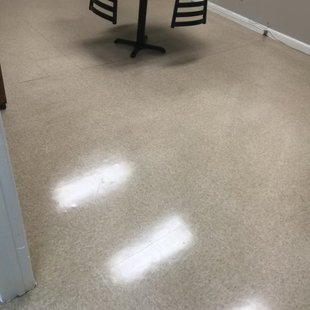 There is a table and chairs on the floor in the room.