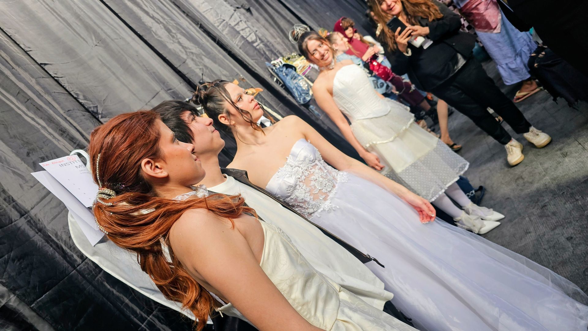 Mujer con un vestido dorado brillante con una abertura hasta el muslo, posando sobre un fondo blanco.