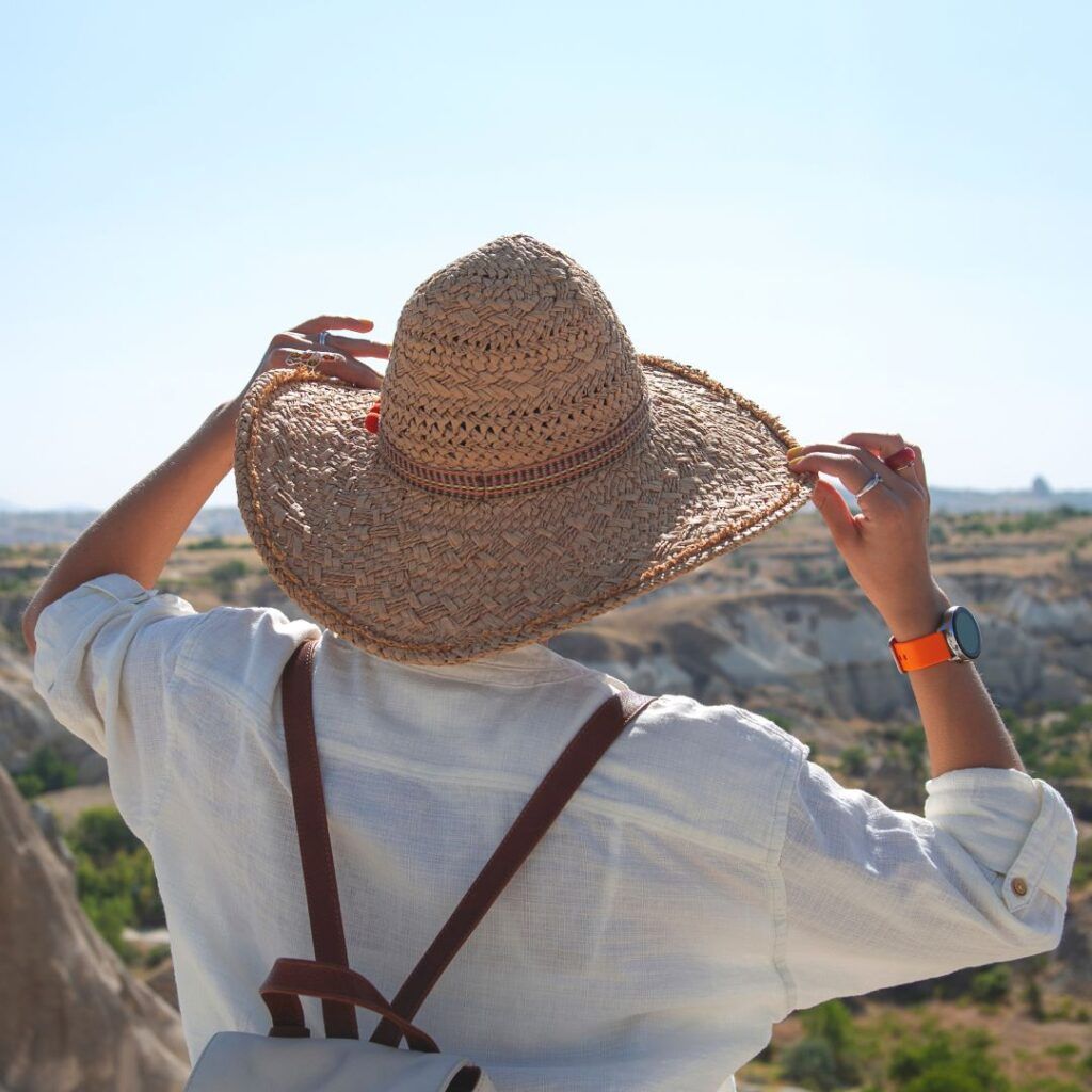 A person wearing a straw hat and a backpack