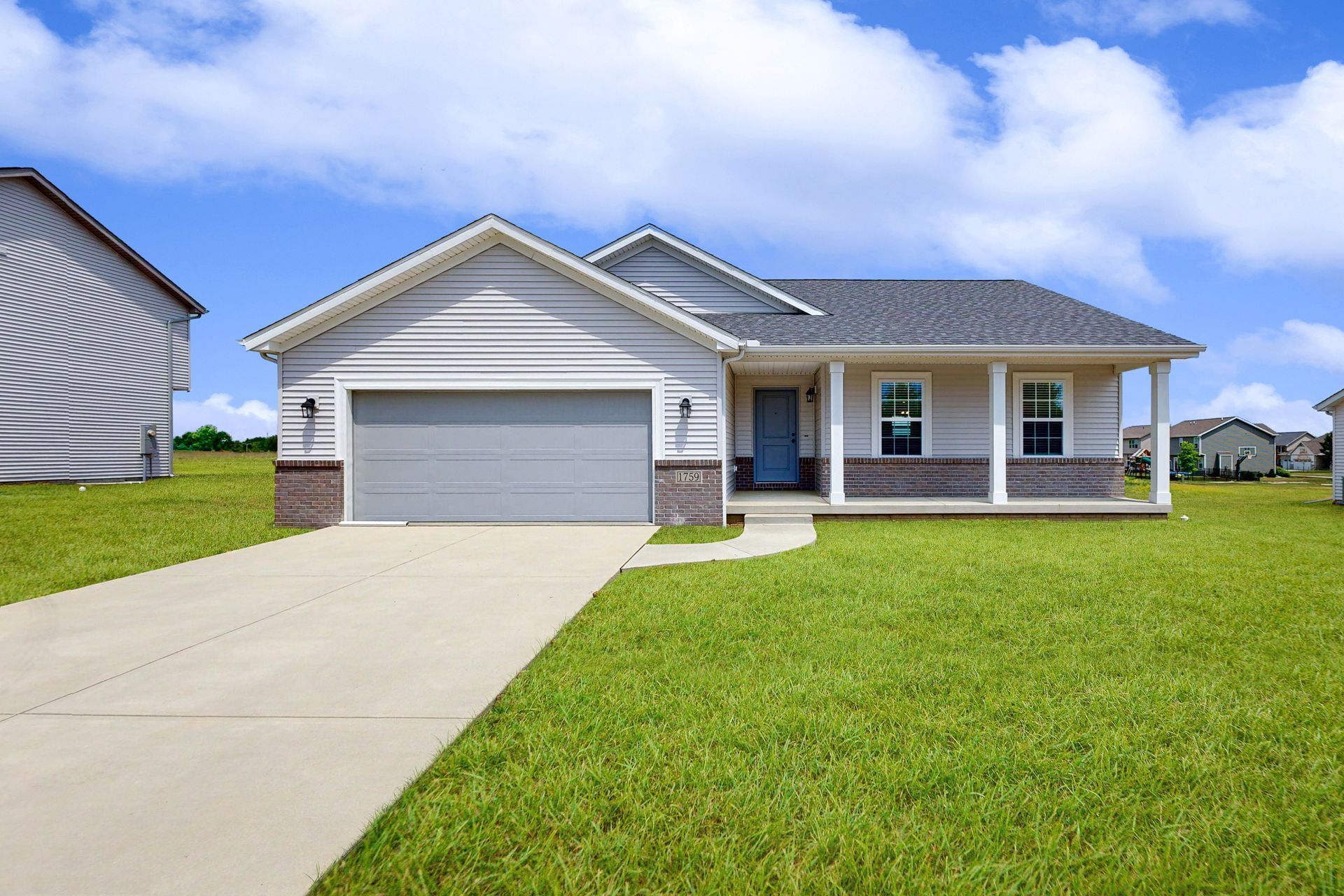 A white house with a gray garage door and a porch