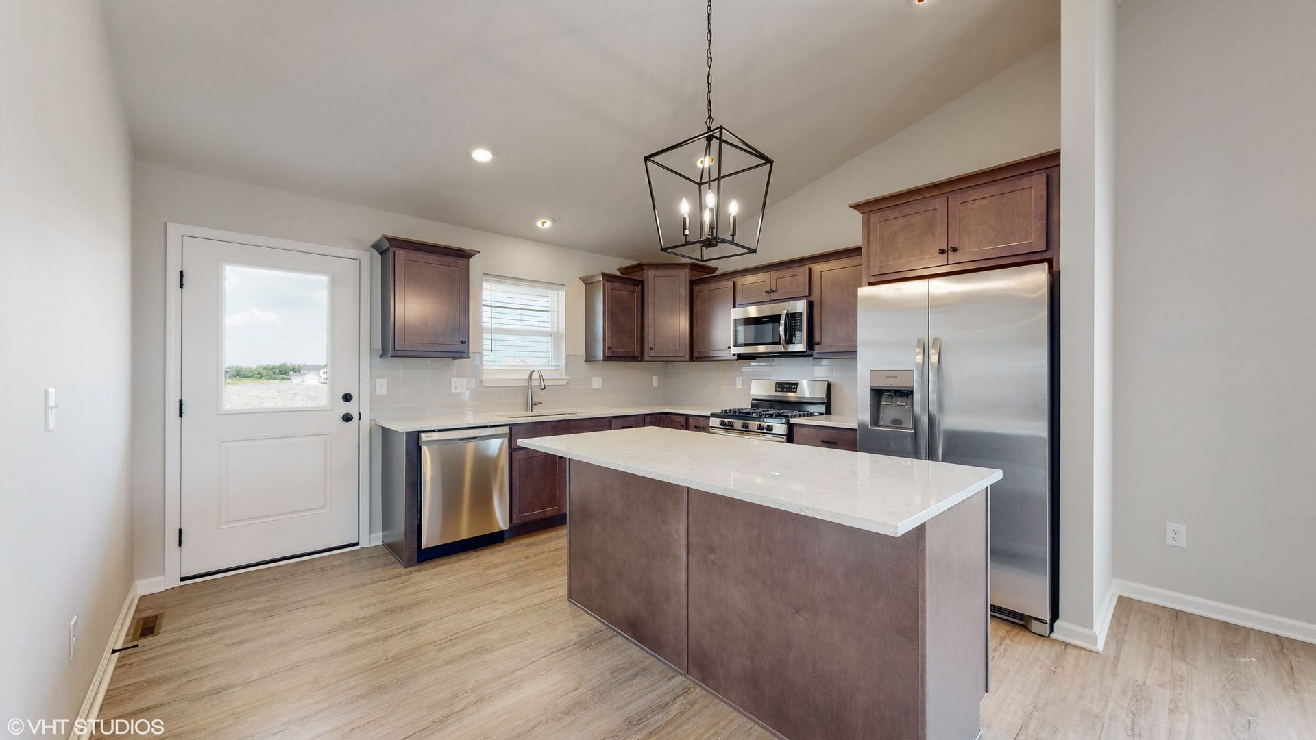 A kitchen with stainless steel appliances and a large island.