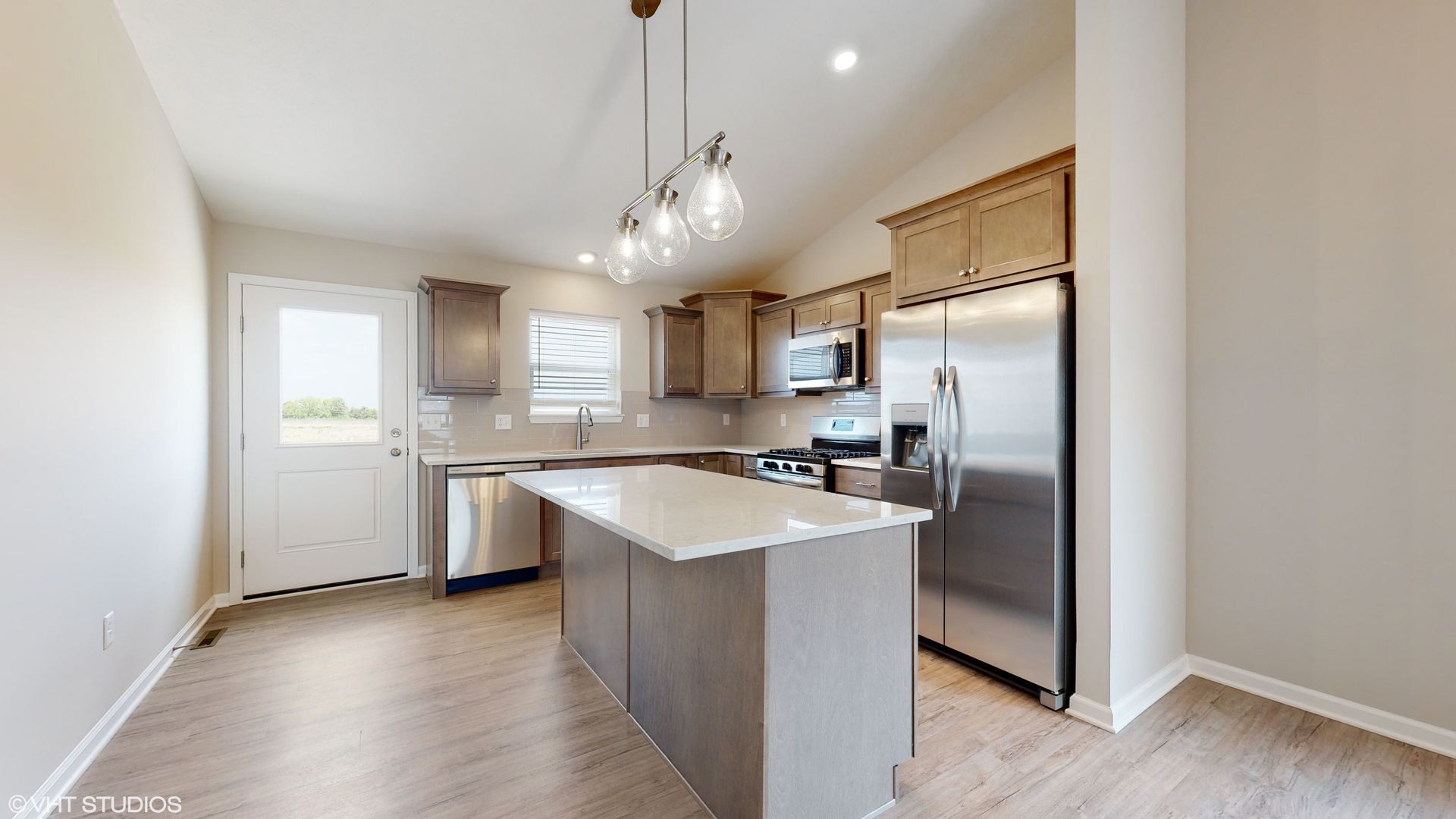 A kitchen with stainless steel appliances and a large island.