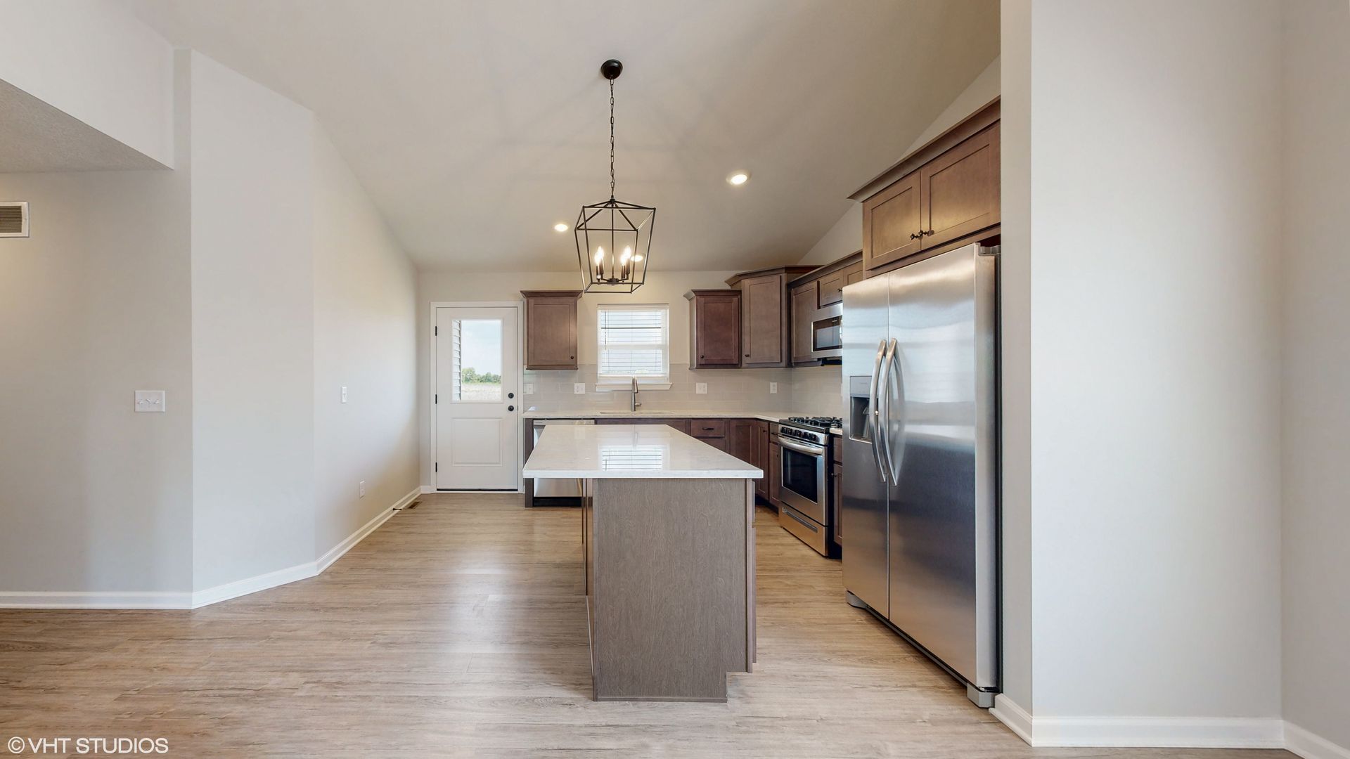 A kitchen with stainless steel appliances and a large island.