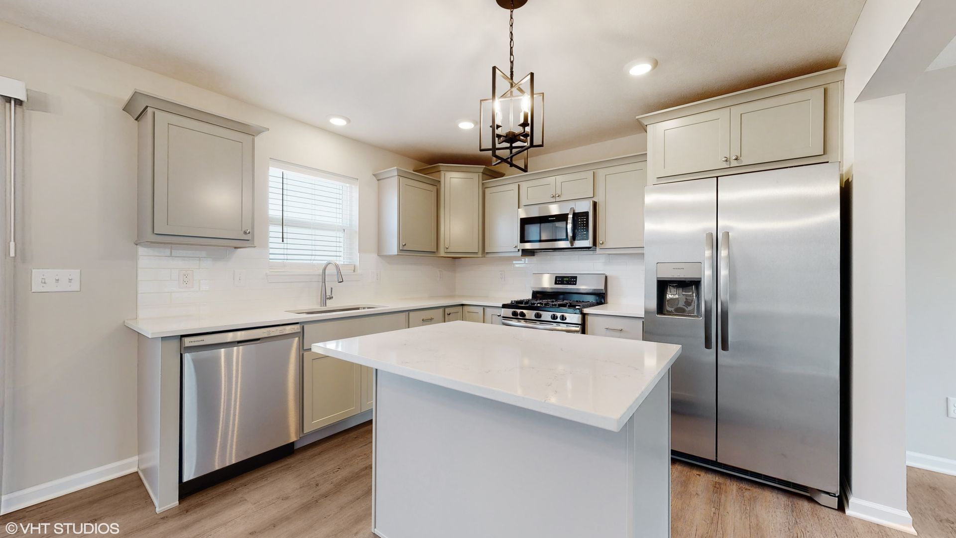 A kitchen with stainless steel appliances and white cabinets.