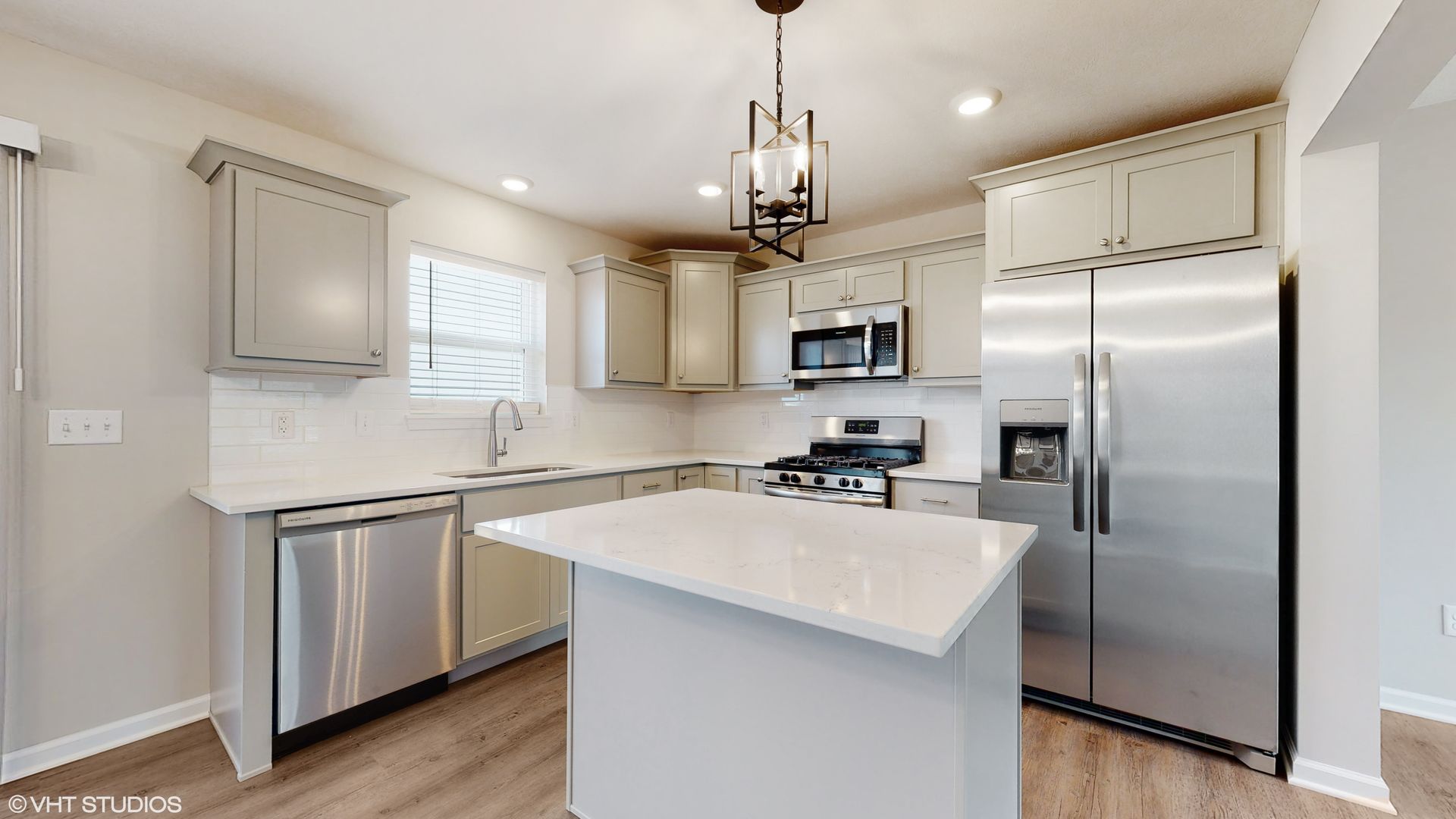 A kitchen with stainless steel appliances and white cabinets.
