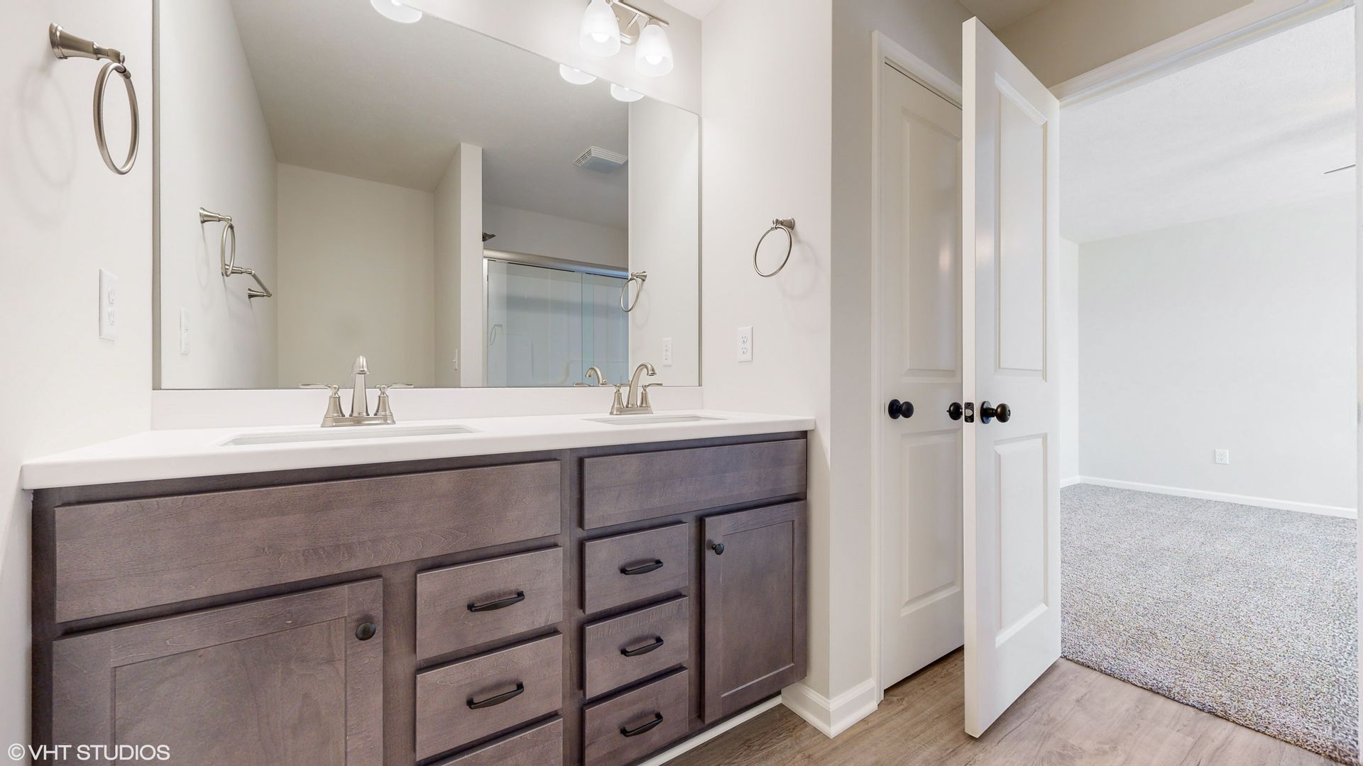 A bathroom with two sinks and a large mirror.