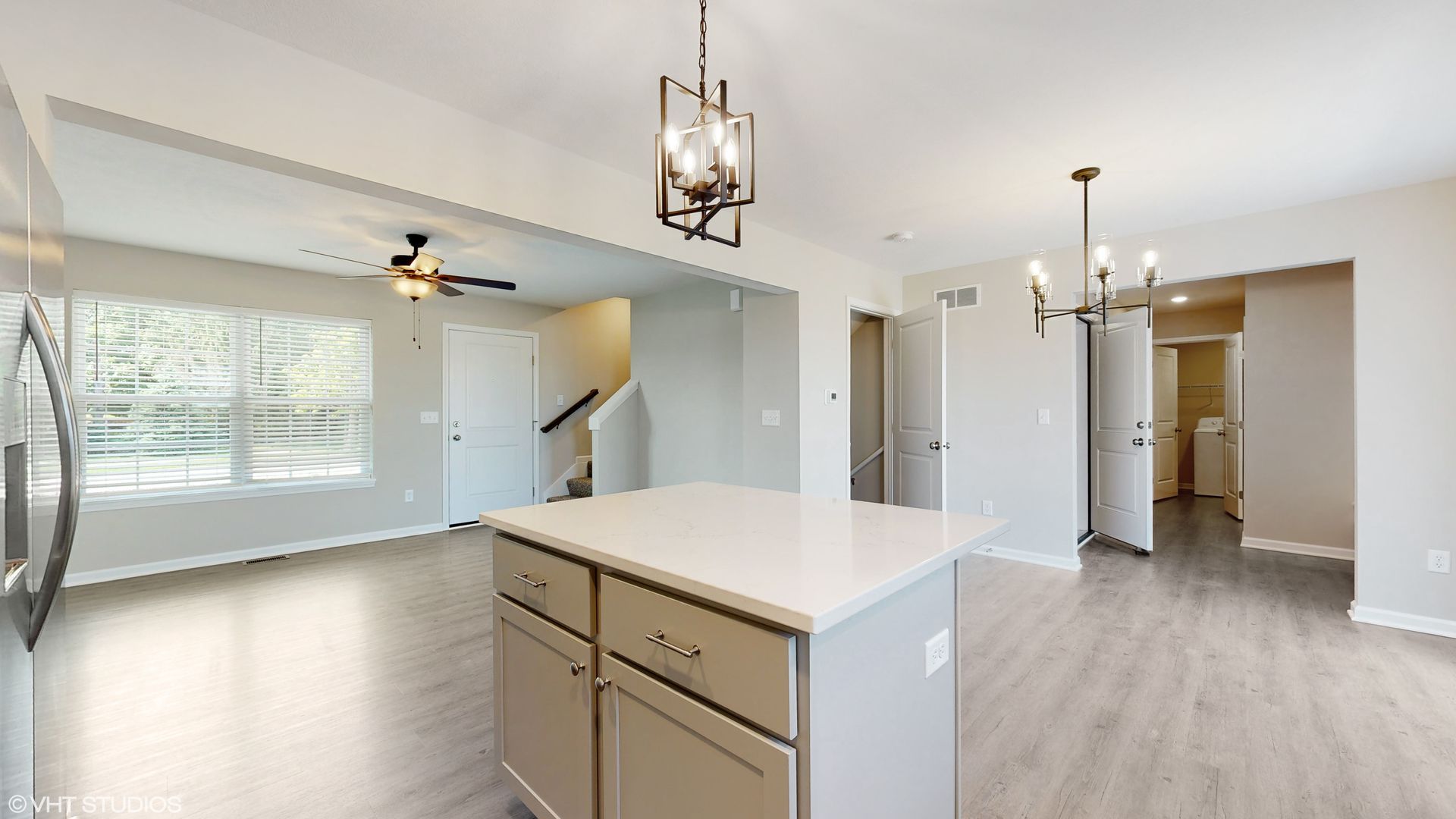 A kitchen with a large island and a ceiling fan.
