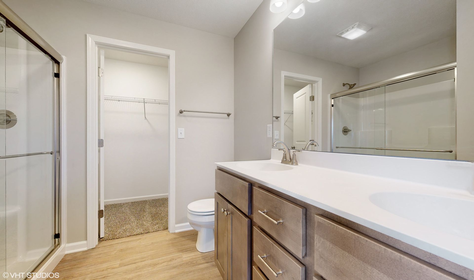 A bathroom with a sink , toilet , shower and mirror.