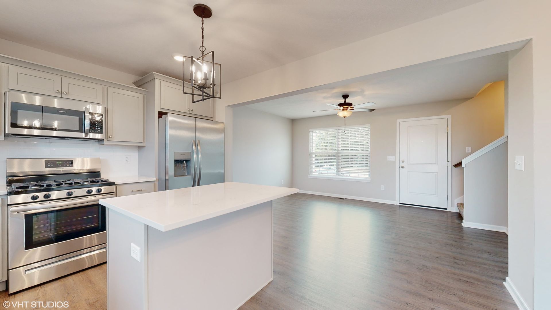 A kitchen with stainless steel appliances and a large island.