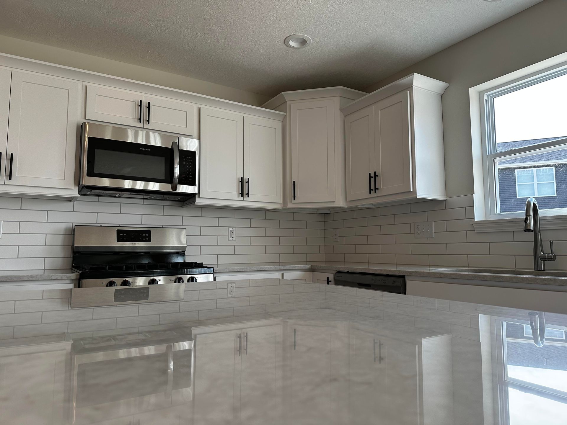 A kitchen with white cabinets and stainless steel appliances