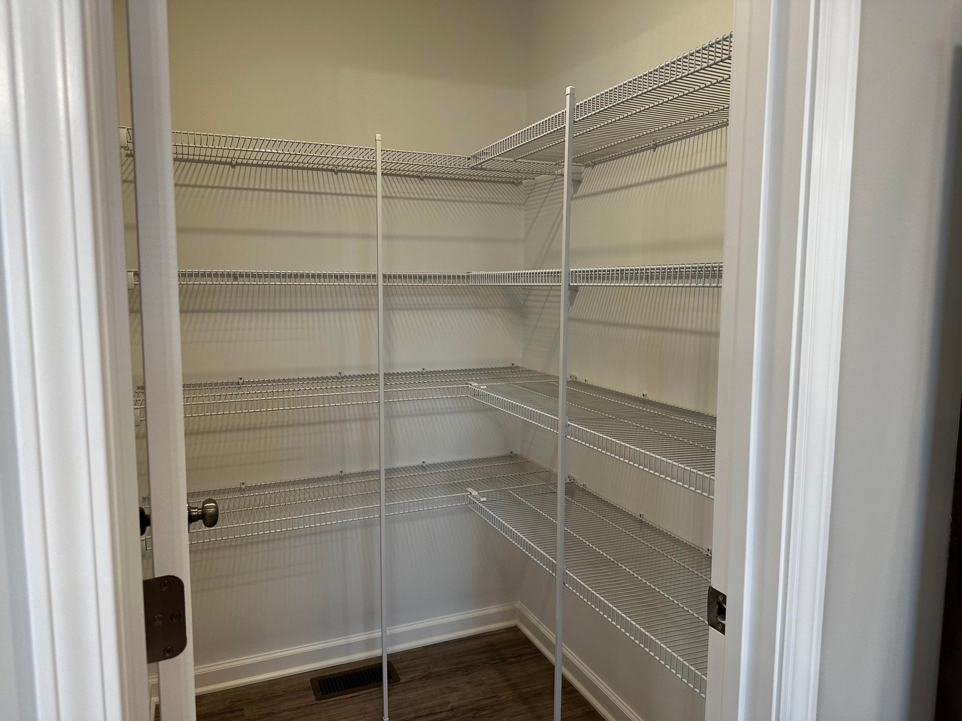 A pantry with shelves and a door in a house.