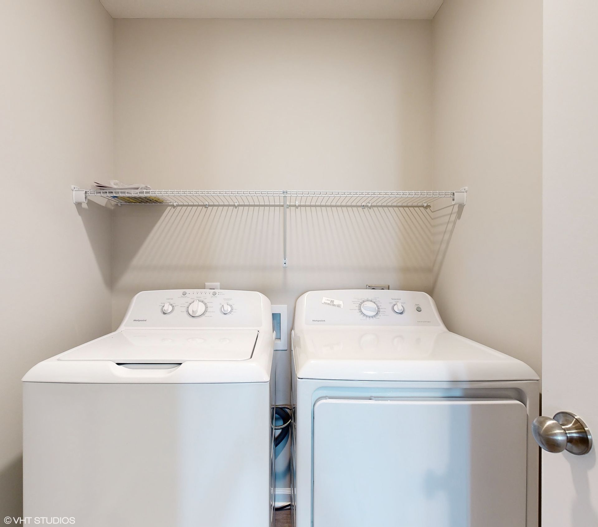 A laundry room with two white washers and dryers.