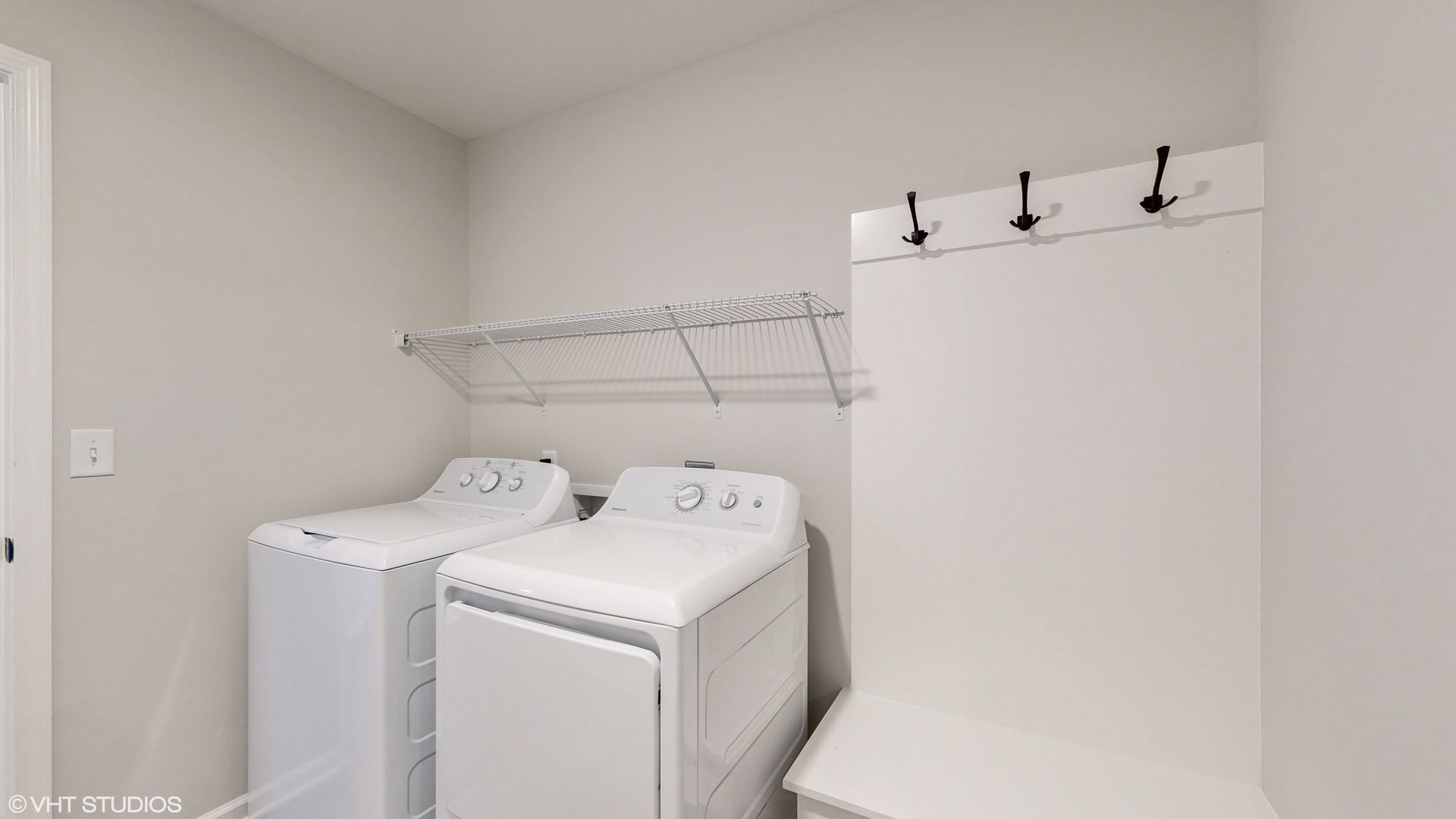 A laundry room with a washer and dryer and a coat rack.