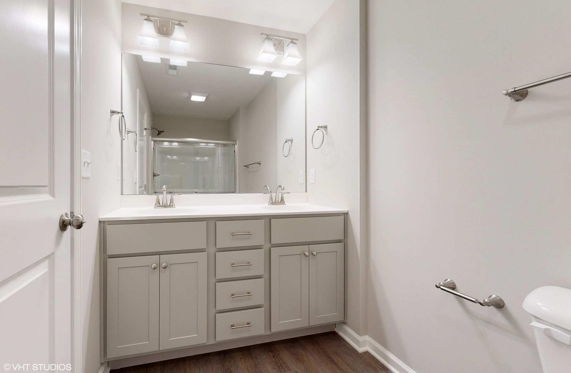 A bathroom with two sinks and a large mirror.
