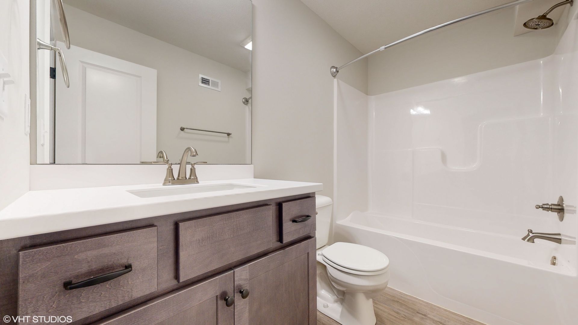 A bathroom with a sink , toilet , bathtub and mirror.