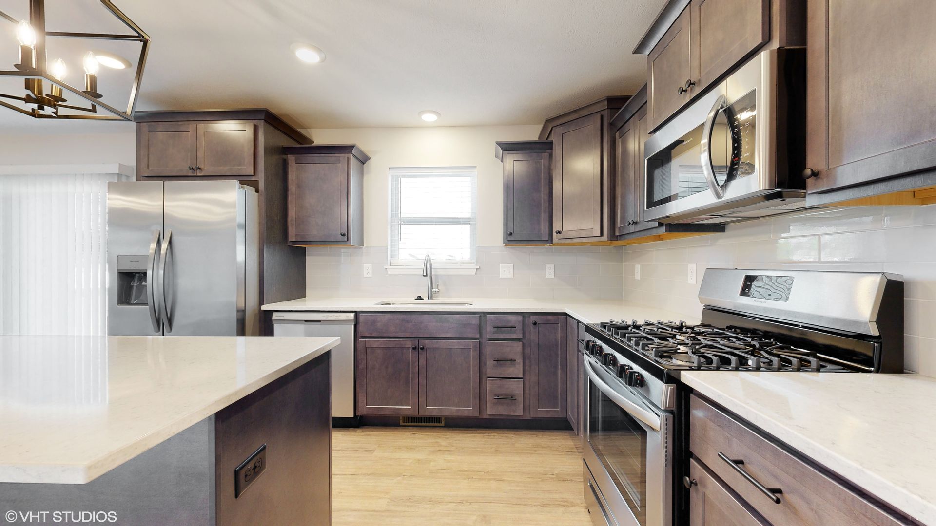 A kitchen with stainless steel appliances and wooden cabinets.
