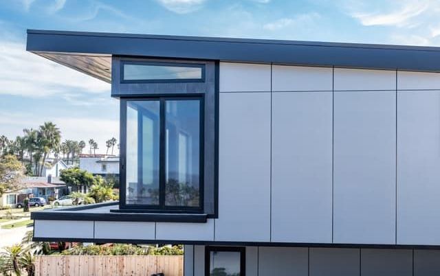 A modern house with a lot of windows and a balcony.