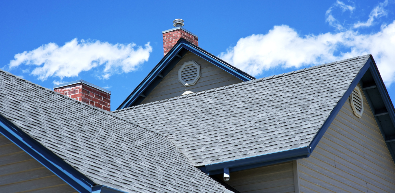 A house with a gray roof and a chimney on top of it.