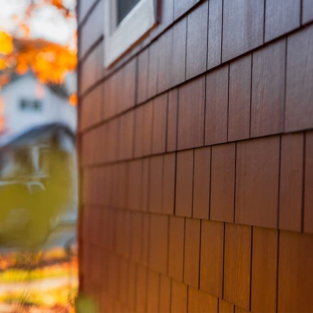 A close up of a wooden siding on a house.