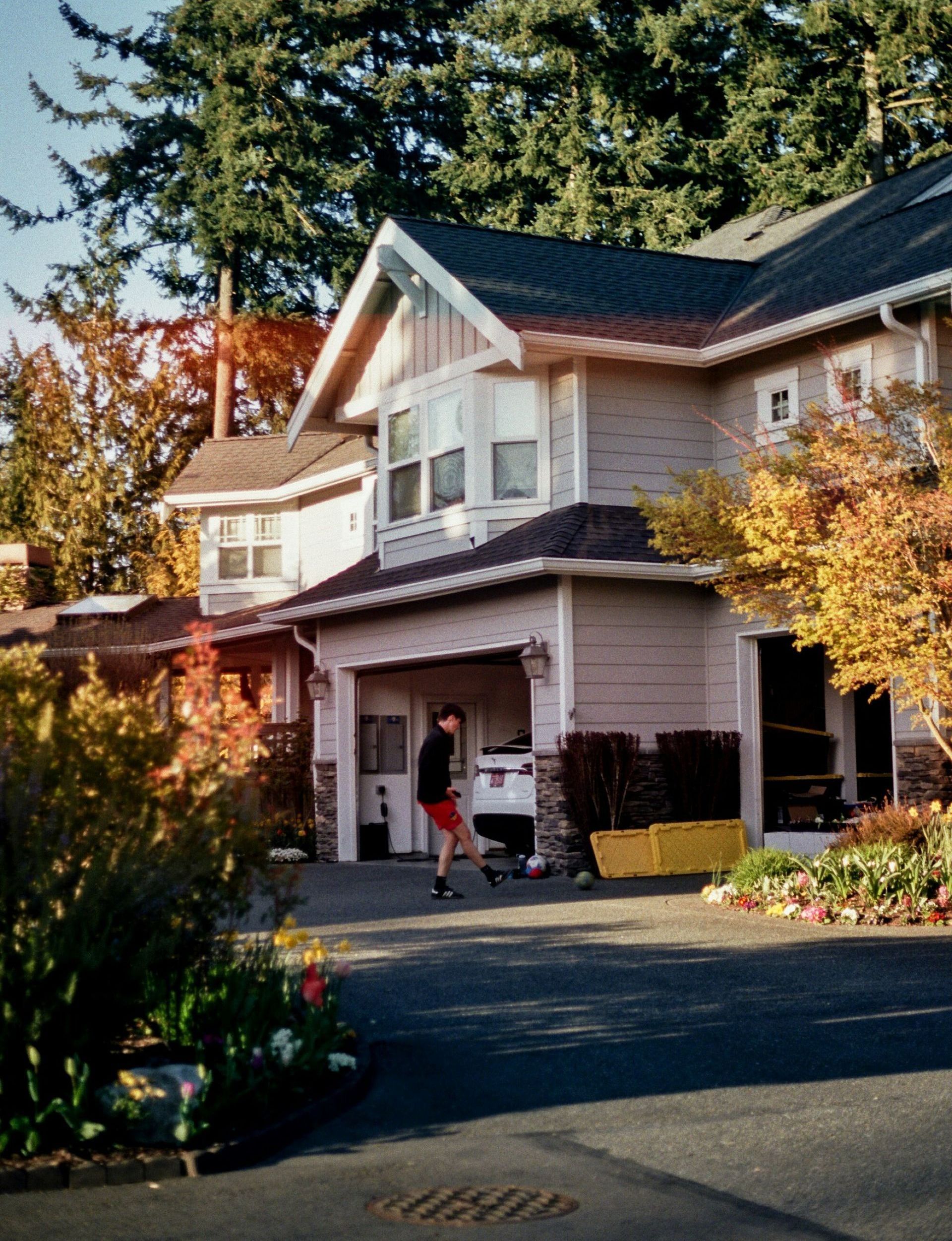 A man is standing in front of a large house