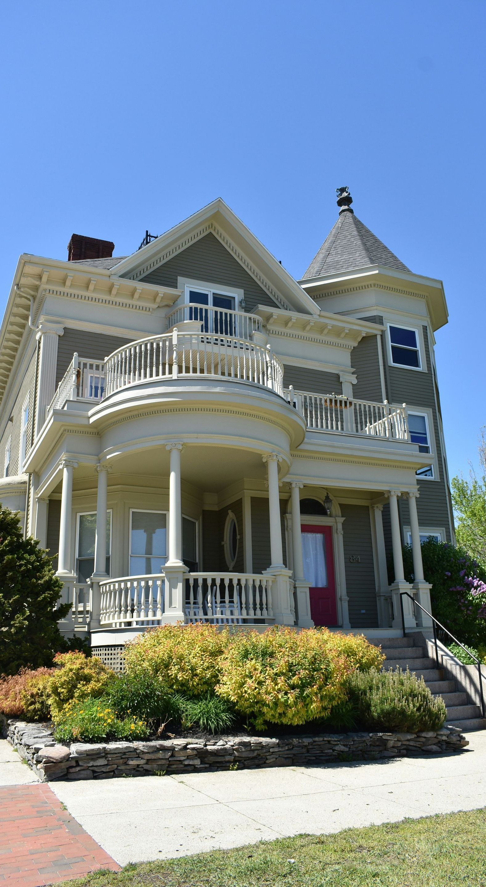 A large house with a large porch and a red door.