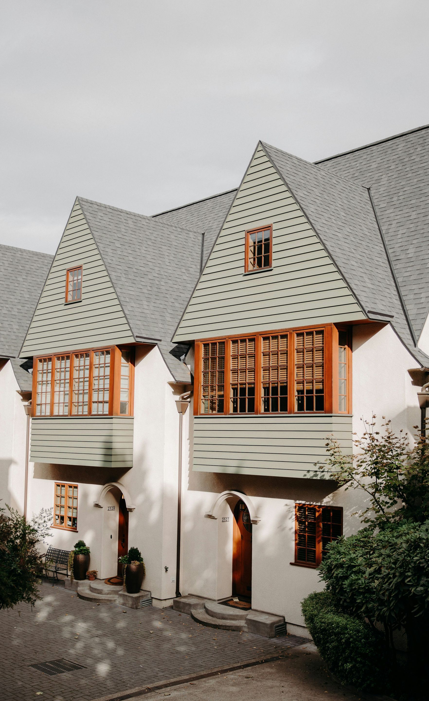 A white house with a green roof and a lot of windows