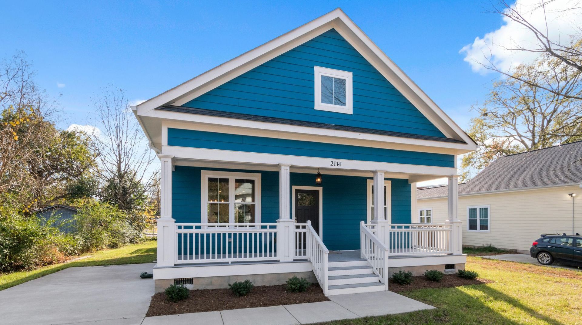 A blue and white house with a porch and stairs.