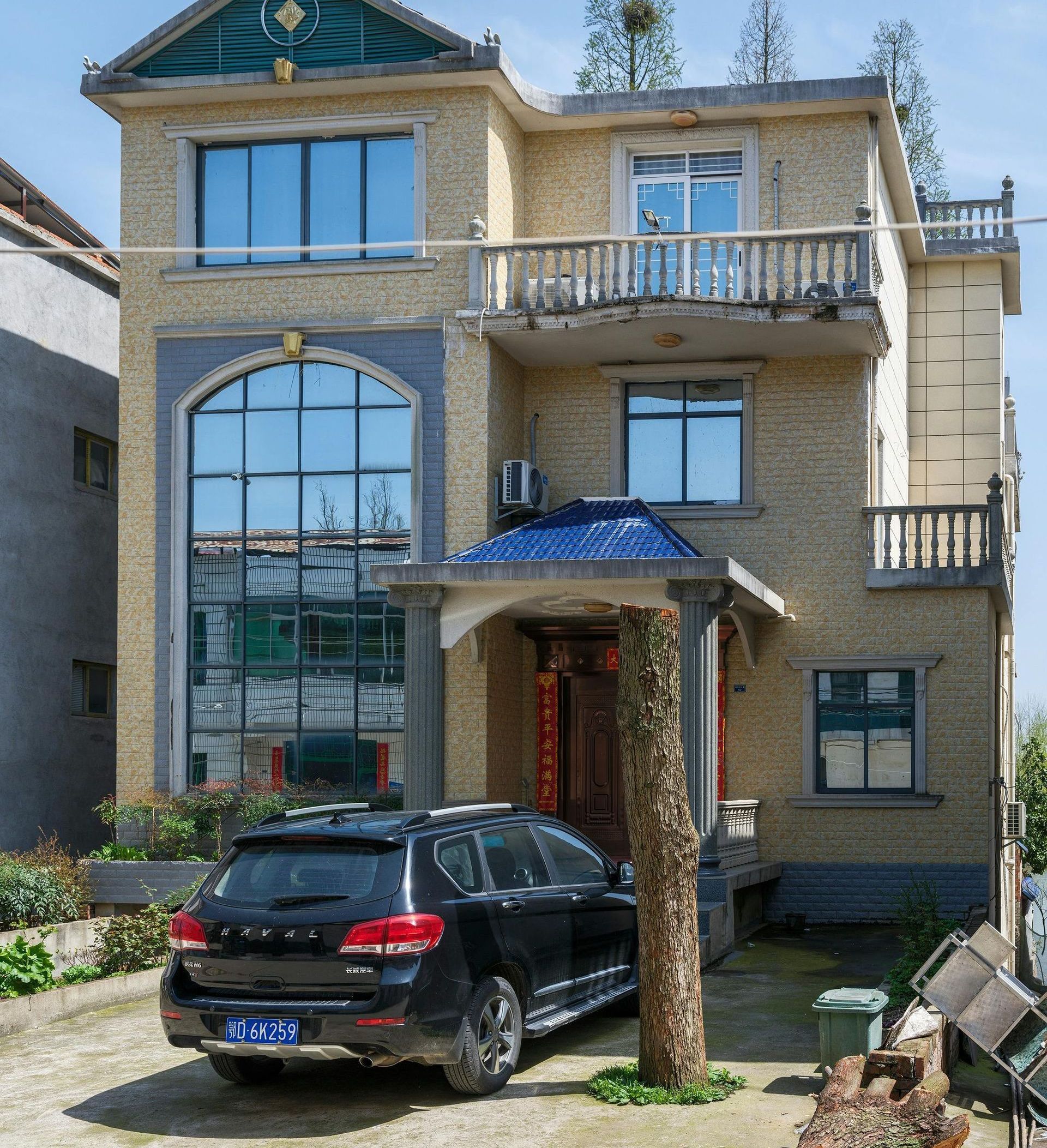 A car is parked in front of a large house