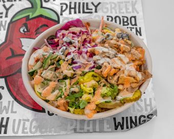 A bowl of food with a lot of vegetables in it