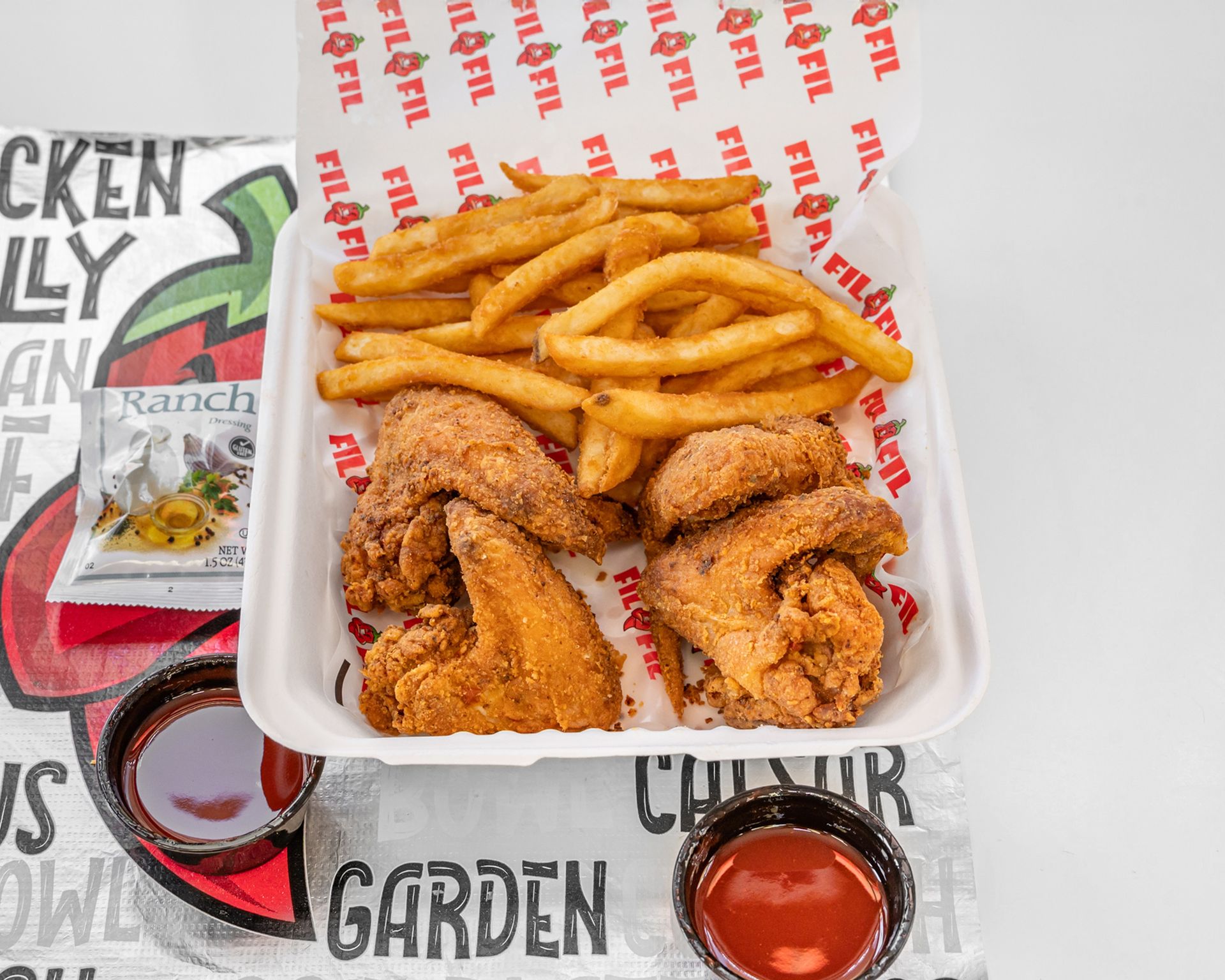 A plate of fried chicken and french fries with a dipping sauce.