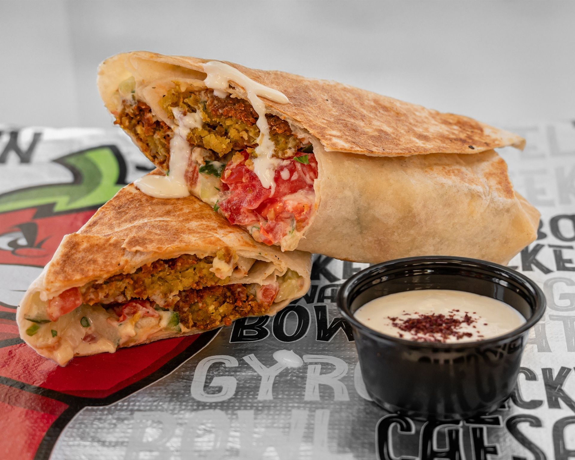 A plate of fried shrimp with a dipping sauce and a lemon wedge.