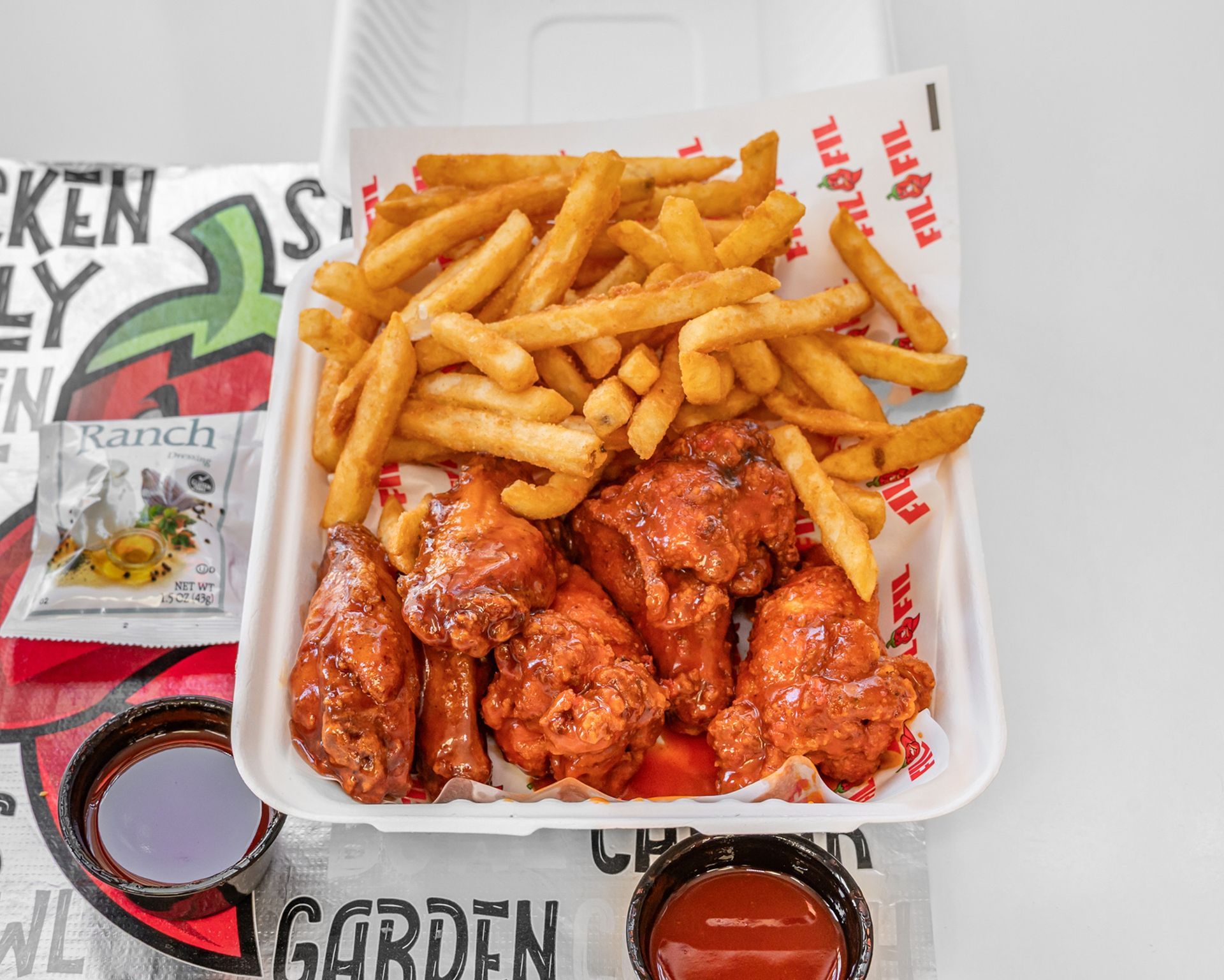 A wooden table topped with fried chicken wings and a bowl of ranch dressing.