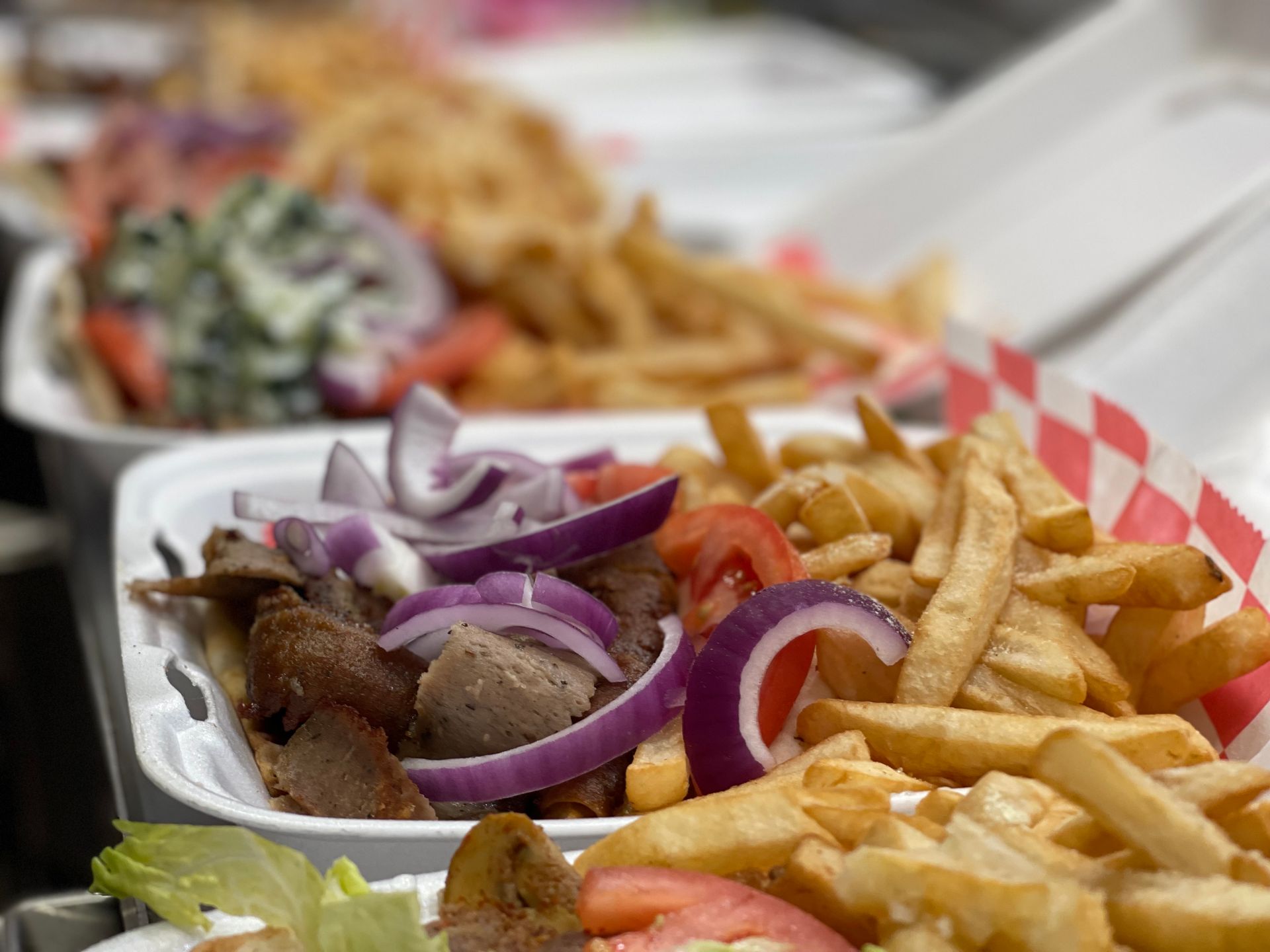 A tray of gyros and french fries on a table.