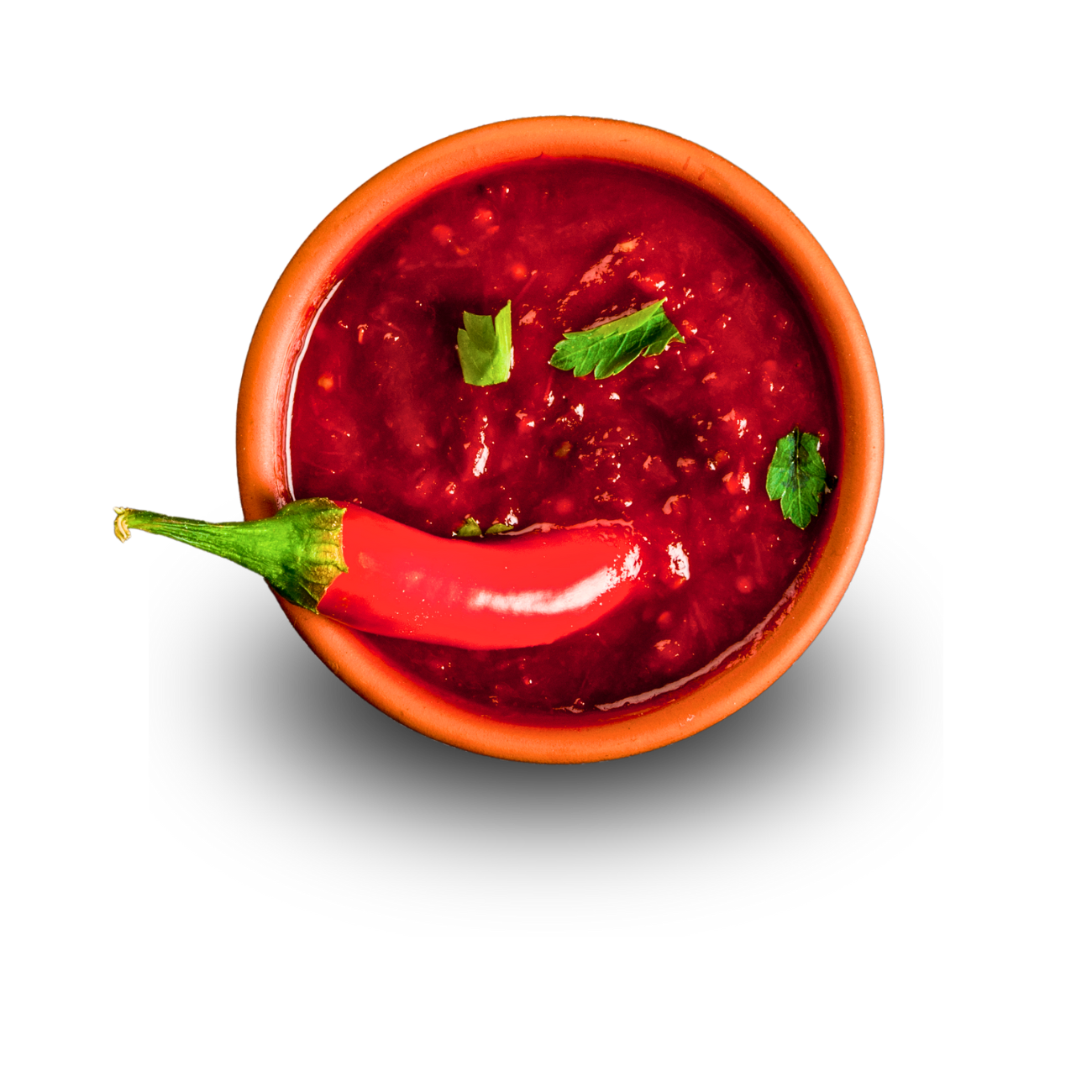 A bowl of sauce with a red pepper in it