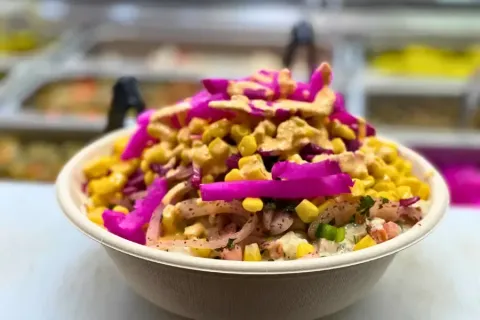 Bowl with corn, pickled vegetables, and sauce.