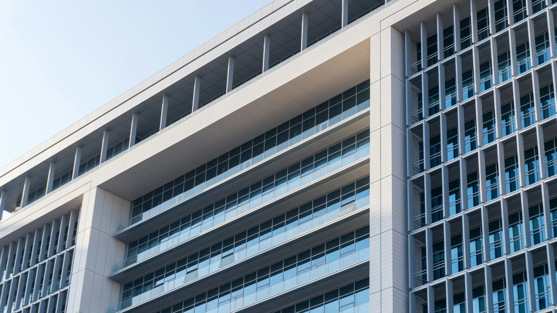 Modern building exterior with glass windows and vertical architectural details.