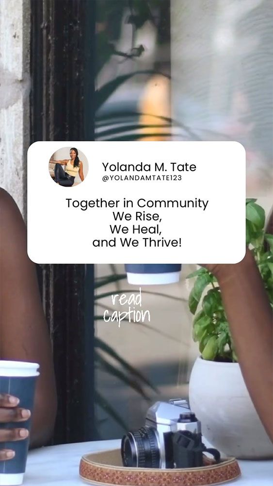 A woman is sitting at a table with a cup of coffee and a camera.