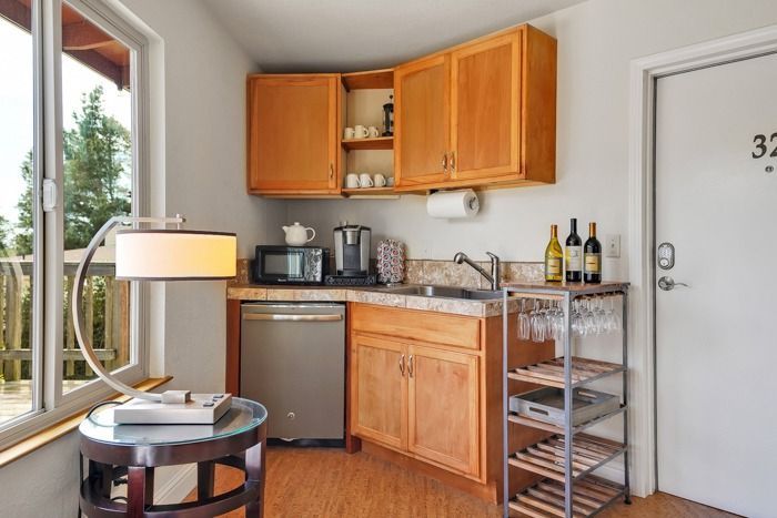 A small kitchen with wooden cabinets and a wine rack