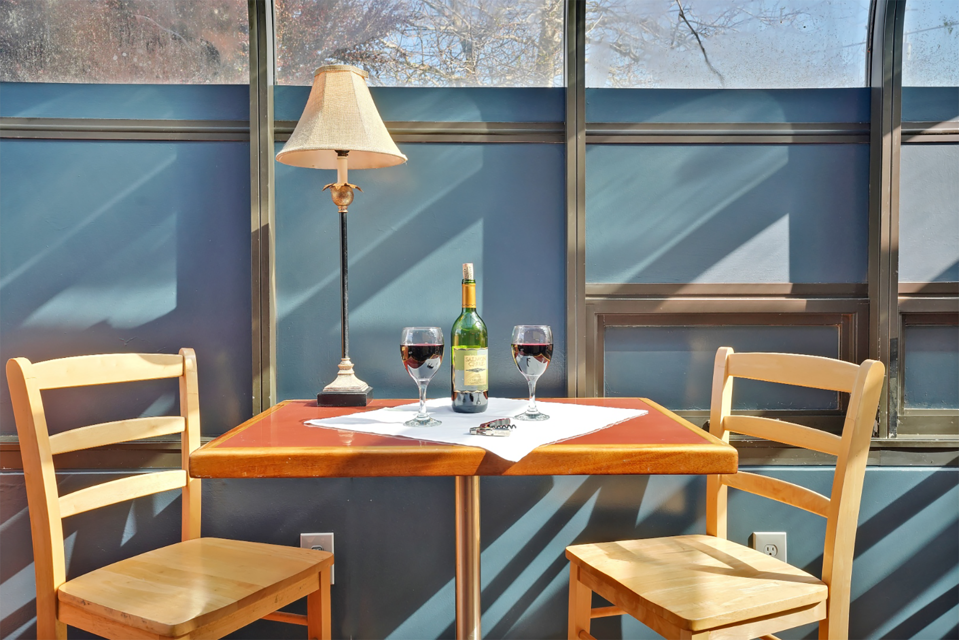 A table with a bottle of wine and two glasses on it