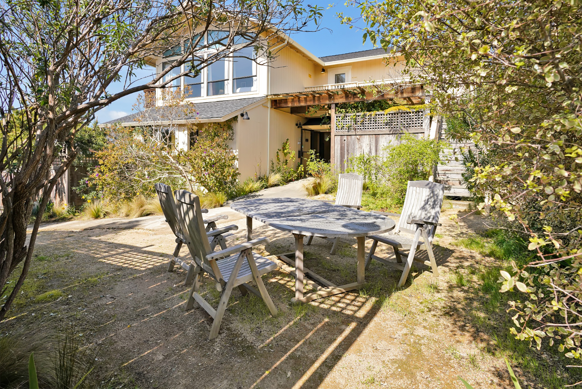 There is a table and chairs in front of a house.