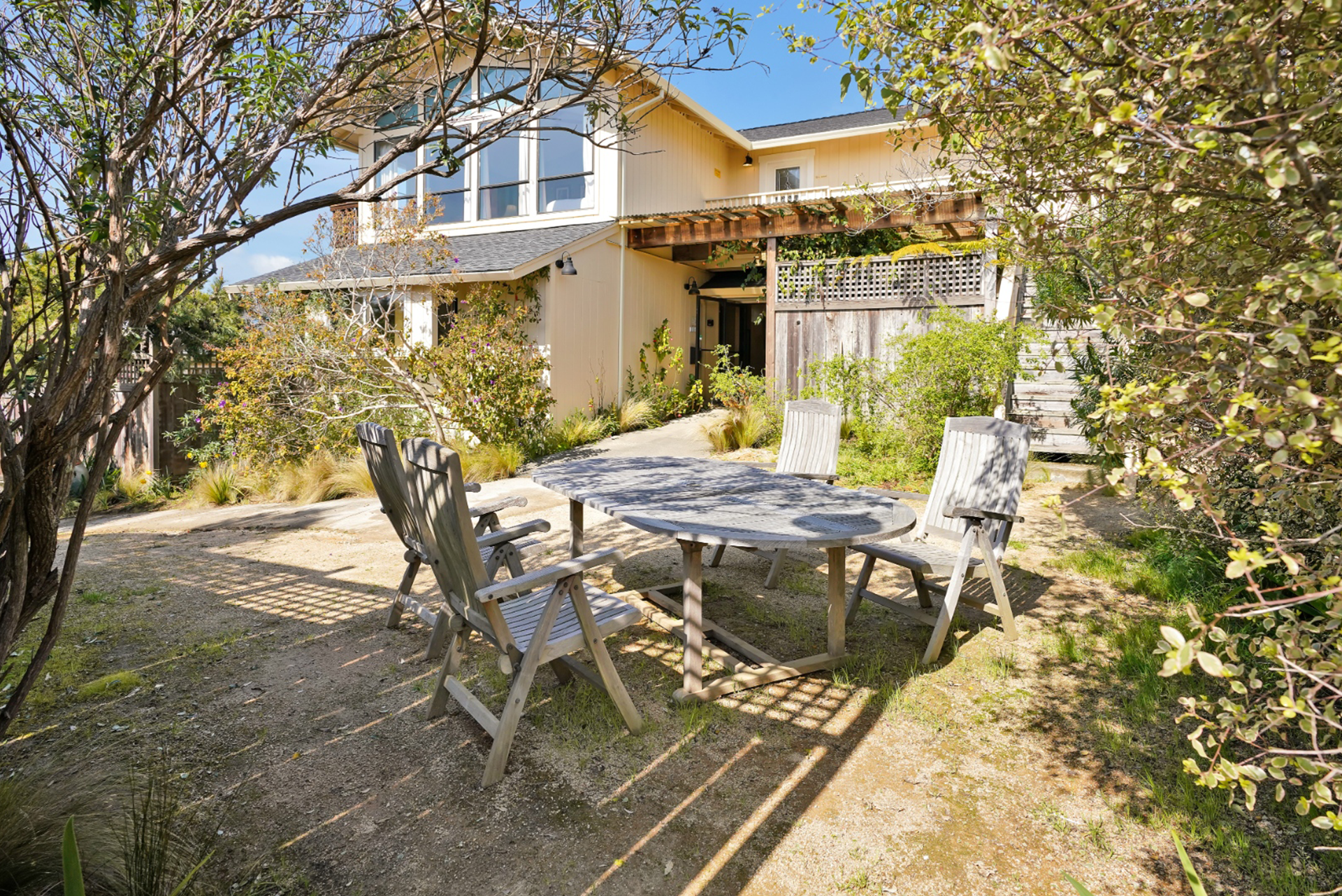 There is a table and chairs in the backyard of a house.
