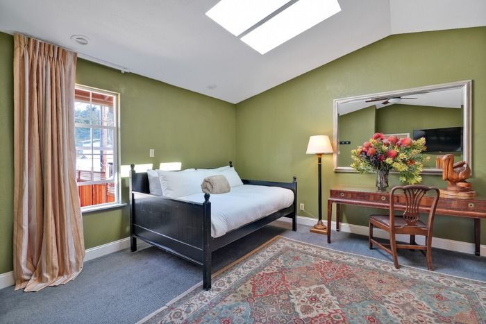 A bedroom with green walls and a day bed