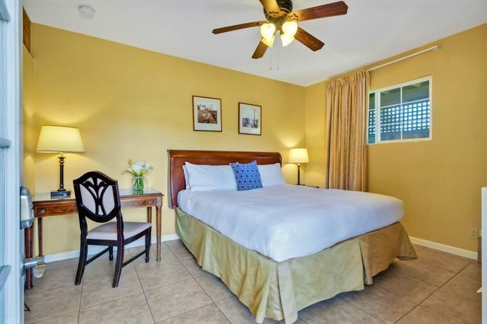 A bedroom with a king size bed and a ceiling fan